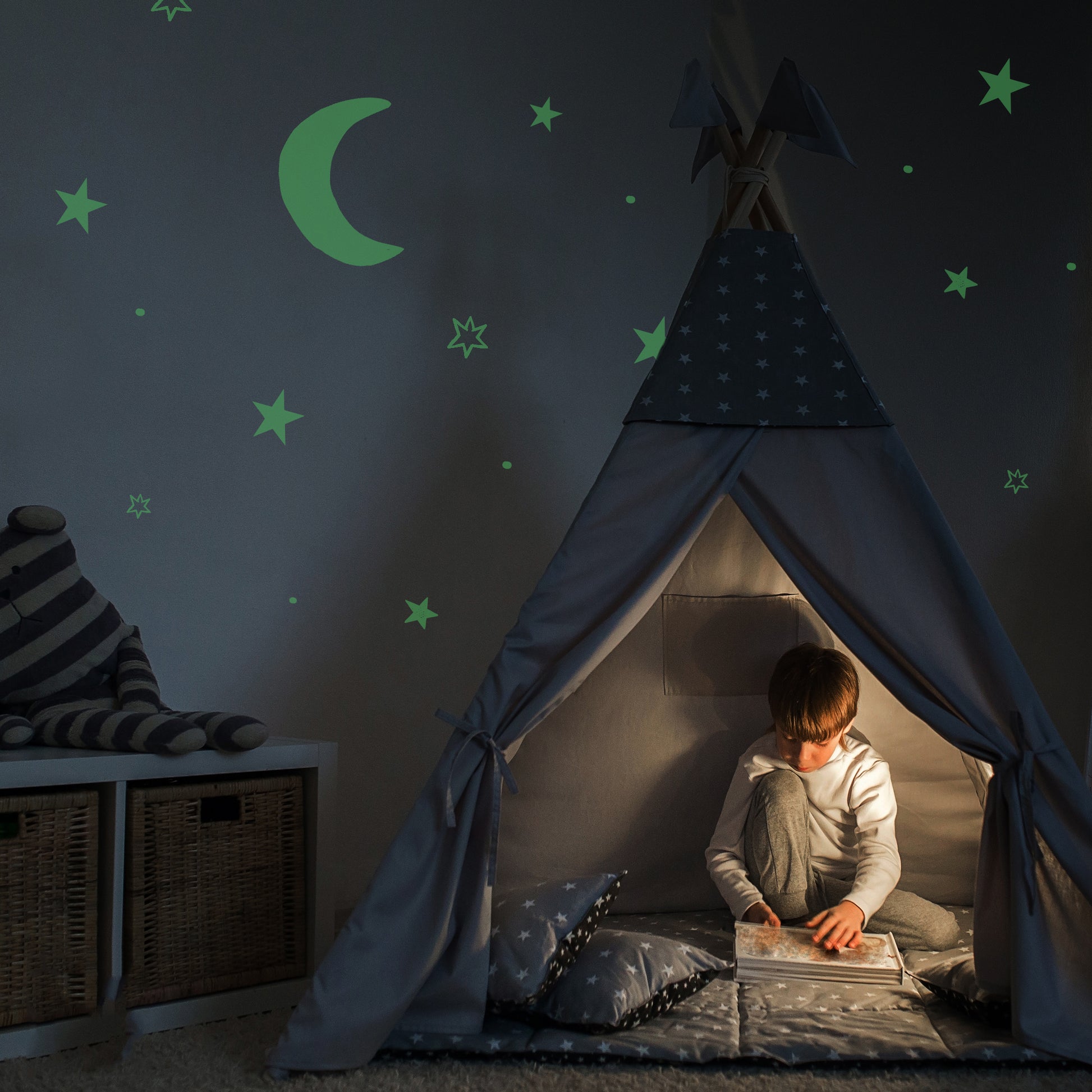 Glow paint stars and moons boy reading in a den